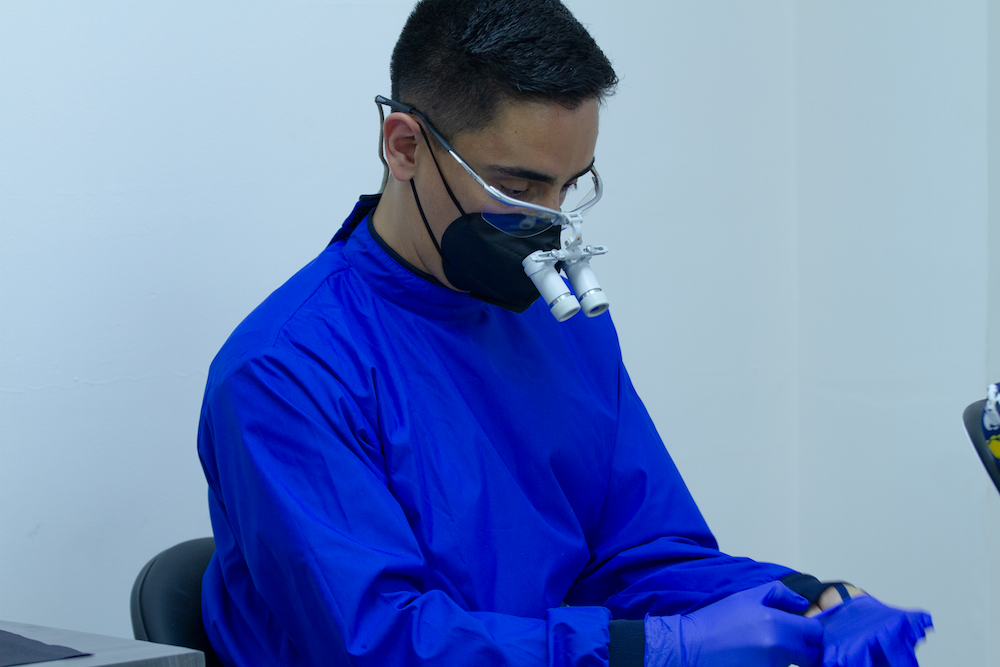 Dental surgeon putting on gloves