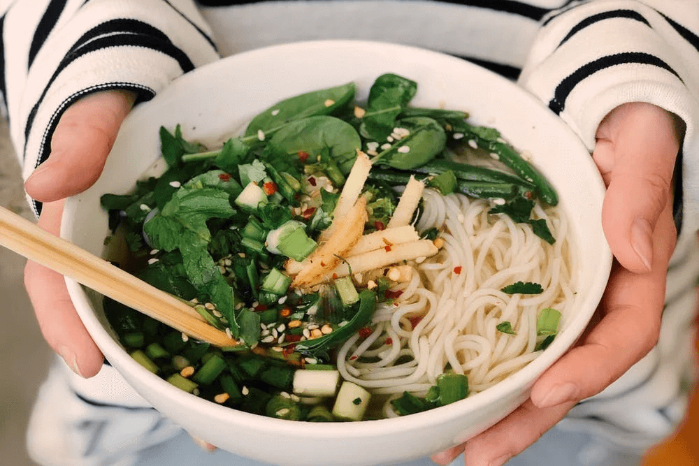 Bariatric Friendly Chicken Pho in bowl being held by person.